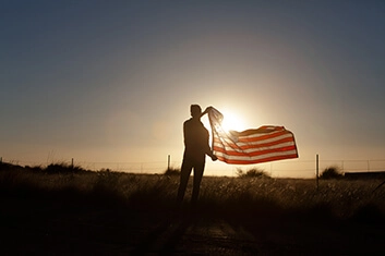 A person hanging the American flag in a shine of sun ray